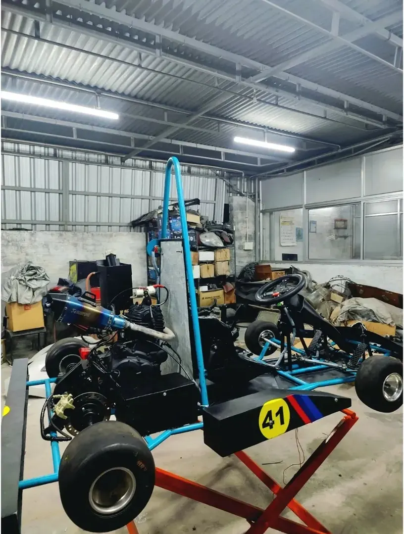 The kart up on stands inside a corrugated workshop before the event.