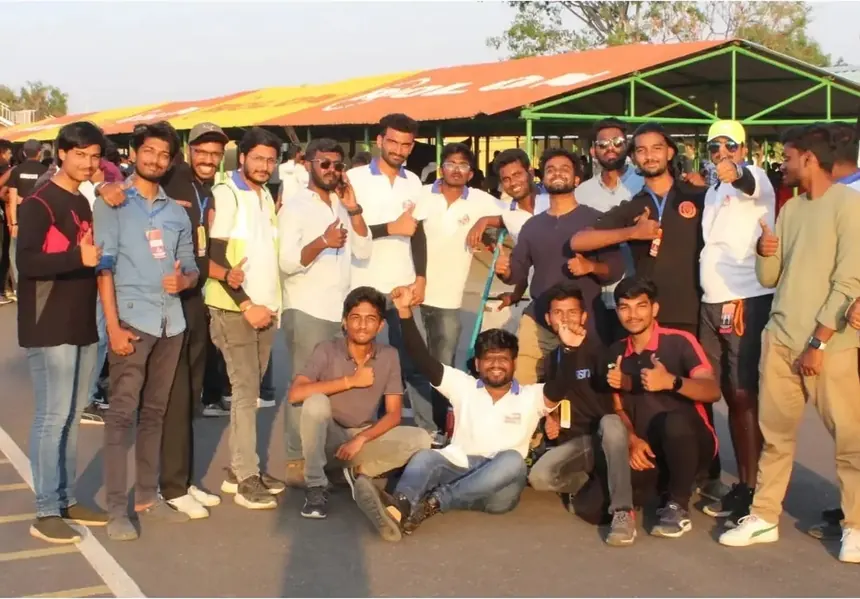 A large group of team members and volunteers under the GKDC paddock tent.