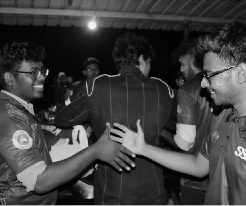 Two team members shaking hands after a run, shot in black and white.