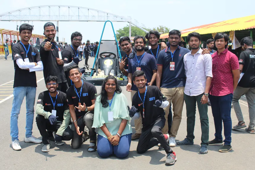 The combustion era team crowded around the kart for a group photo.